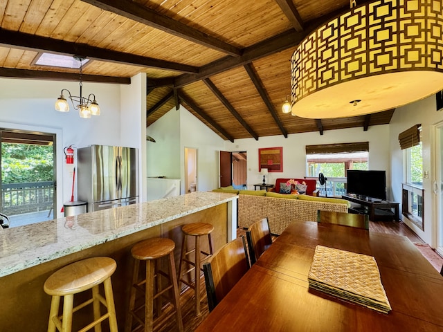 4523 Uku Lii Pl, Hanalei, HI 96714 - kitchen featuring freestanding refrigerator, wood ceiling, wood finished floors, light stone counters, and hanging light fixtures