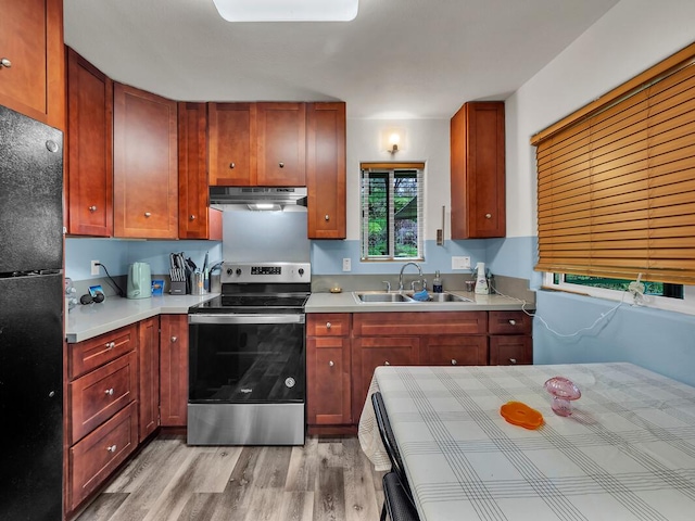 11-3057 Anuhea St, Volcano, HI 96785 - kitchen with stainless steel electric range oven, under cabinet range hood, freestanding refrigerator, light wood-style flooring, and light countertops