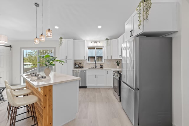 16-2110 Tangerine Dr, Pahoa, HI 96778 - kitchen featuring appliances with stainless steel finishes, decorative backsplash, light wood-type flooring, white cabinetry, and light countertops