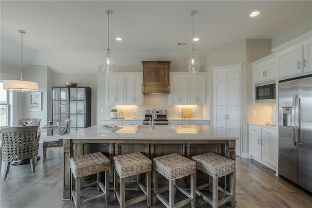 kitchen with pendant lighting, appliances with stainless steel finishes, and white cabinetry