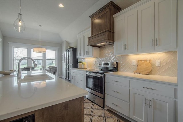 kitchen featuring electric range, sink, white cabinets, tasteful backsplash, and pendant lighting