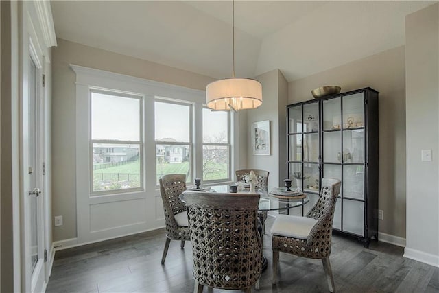 dining area with vaulted ceiling and dark wood-type flooring