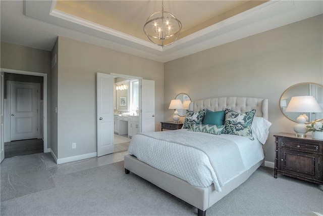 bedroom featuring a notable chandelier, light carpet, a raised ceiling, and ensuite bathroom