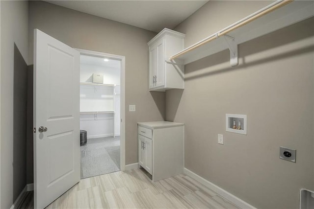 laundry area featuring electric dryer hookup, cabinets, light tile floors, and hookup for a washing machine