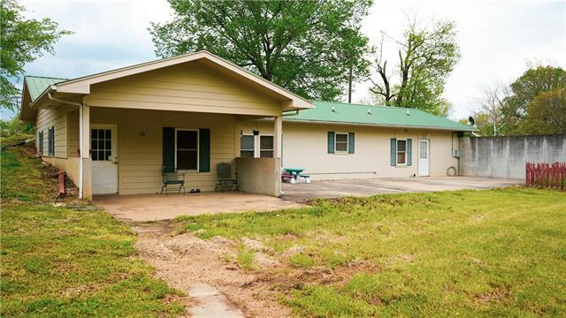 rear view of property featuring a yard and a patio area