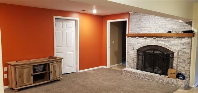 unfurnished living room featuring brick wall, a brick fireplace, and carpet flooring