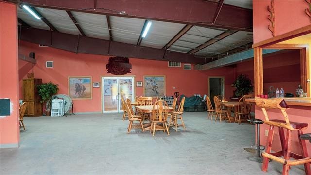 dining room featuring bar and concrete floors