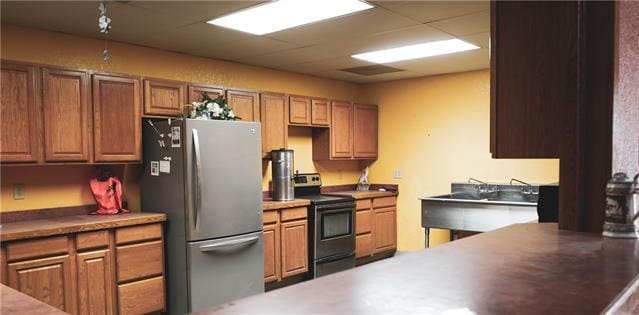 kitchen featuring sink, range with electric stovetop, and stainless steel fridge