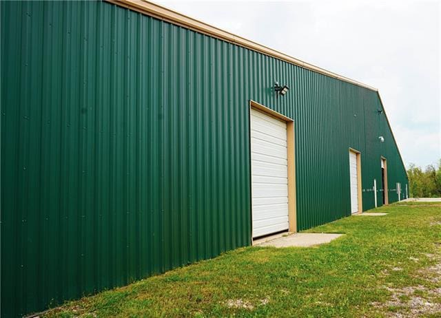 view of outdoor structure featuring a lawn and a garage