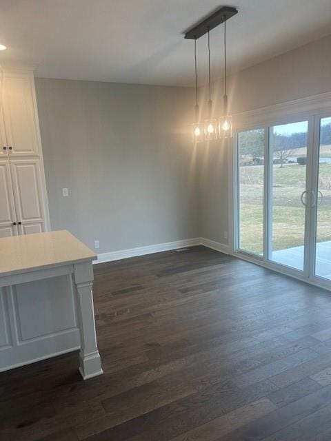 unfurnished dining area with dark wood-type flooring