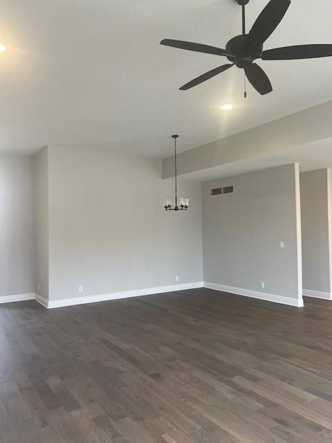 unfurnished room with dark hardwood / wood-style flooring and ceiling fan with notable chandelier