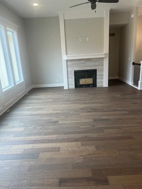 unfurnished living room with a fireplace, hardwood / wood-style flooring, and ceiling fan