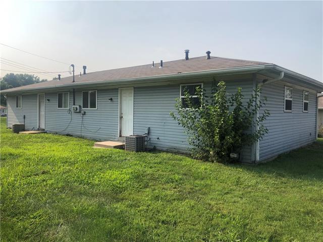 rear view of property featuring central AC unit and a yard