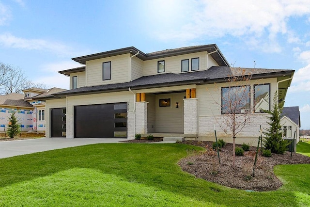 prairie-style home with a garage and a front lawn