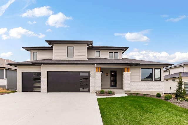 prairie-style house featuring a garage and a front yard