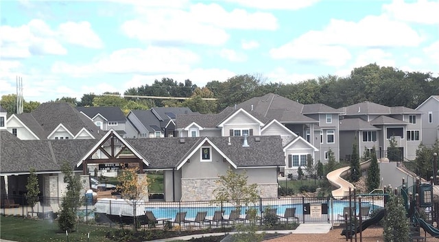 rear view of house with a fenced in pool