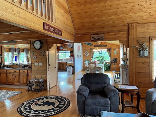 living room featuring wooden walls, vaulted ceiling, and a wealth of natural light