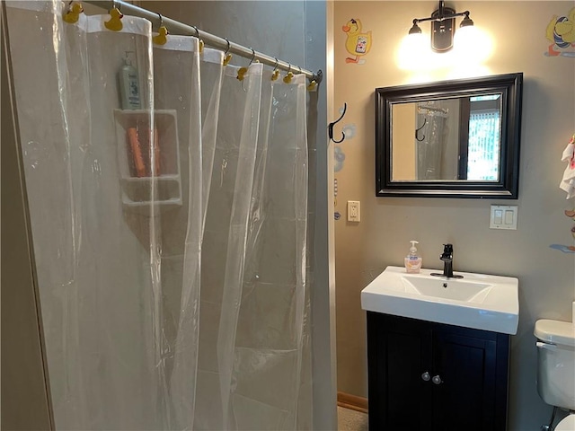 bathroom featuring vanity, toilet, and walk in shower