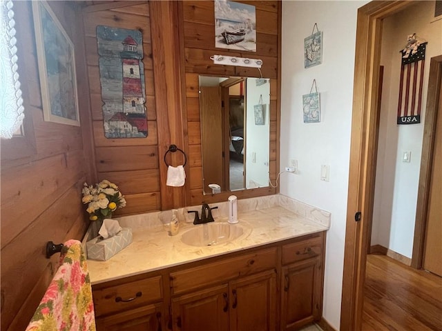 bathroom featuring vanity and wood walls