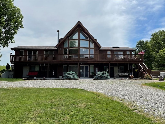 rear view of house with a deck and a lawn