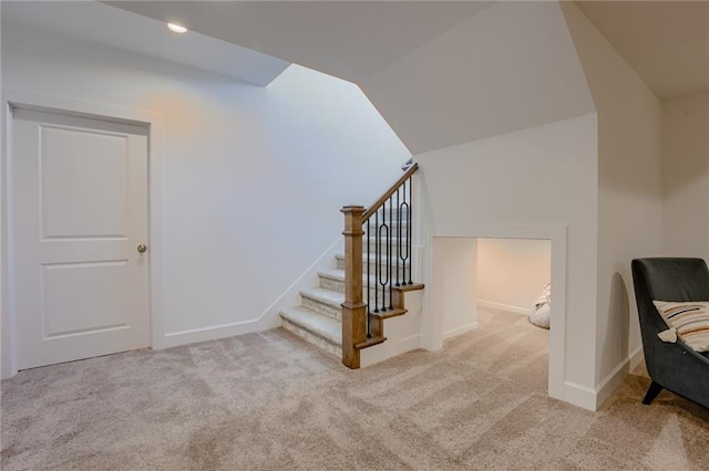 staircase with lofted ceiling and carpet flooring