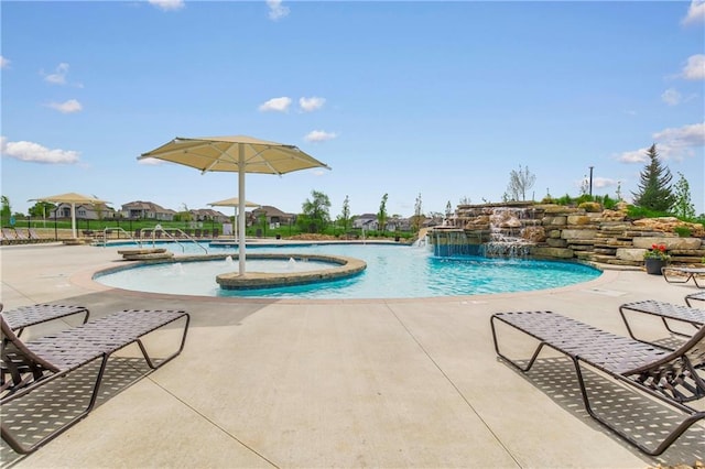 view of pool with a jacuzzi, a patio, and pool water feature