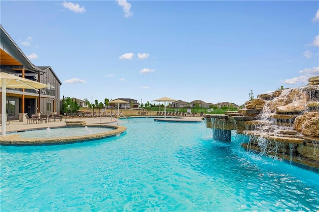 view of pool with pool water feature and a patio