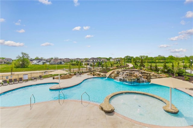 view of swimming pool with a community hot tub, pool water feature, and a patio area