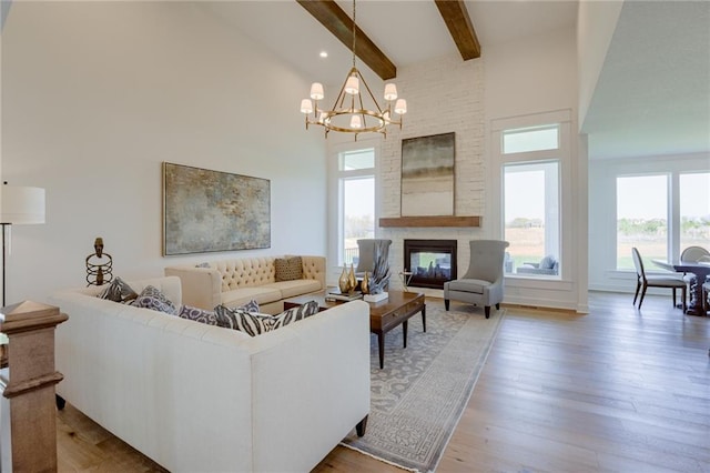 living room with wood-type flooring, a chandelier, high vaulted ceiling, a multi sided fireplace, and beamed ceiling