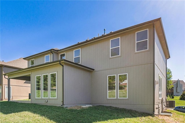 rear view of property featuring a lawn