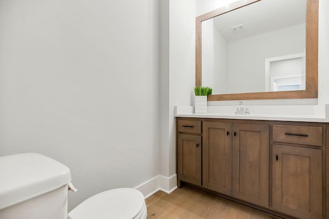 bathroom featuring hardwood / wood-style flooring, vanity, and toilet