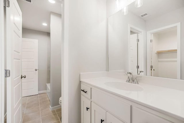 bathroom with tile patterned flooring, vanity, and toilet