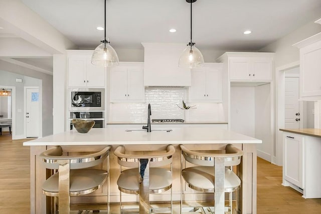 2301 W 180th St, Overland Park, KS 66085 - kitchen with stainless steel oven, built in microwave, decorative backsplash, light wood-style flooring, and white cabinetry