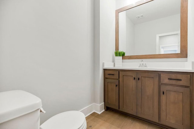 2301 W 180th St, Overland Park, KS 66085 - half bath with toilet, vanity, wood finished floors, and baseboards