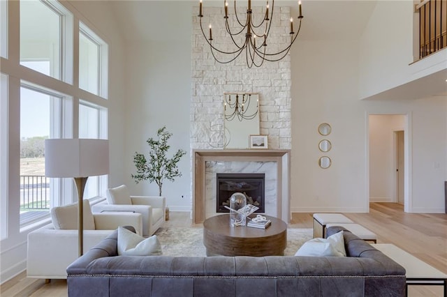 living room with a high ceiling, a notable chandelier, and light wood-type flooring