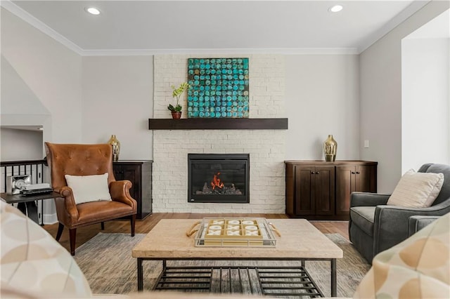 living room featuring a fireplace, ornamental molding, and light wood-type flooring