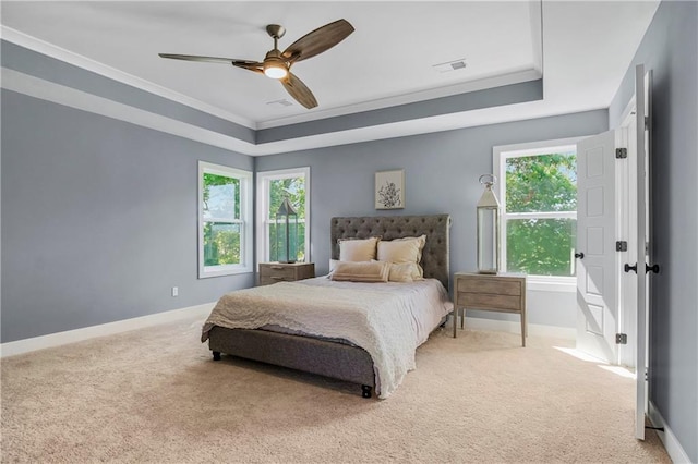 carpeted bedroom featuring crown molding, ceiling fan, and a tray ceiling