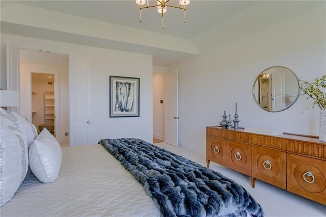 bedroom with a spacious closet, a notable chandelier, a closet, and light carpet