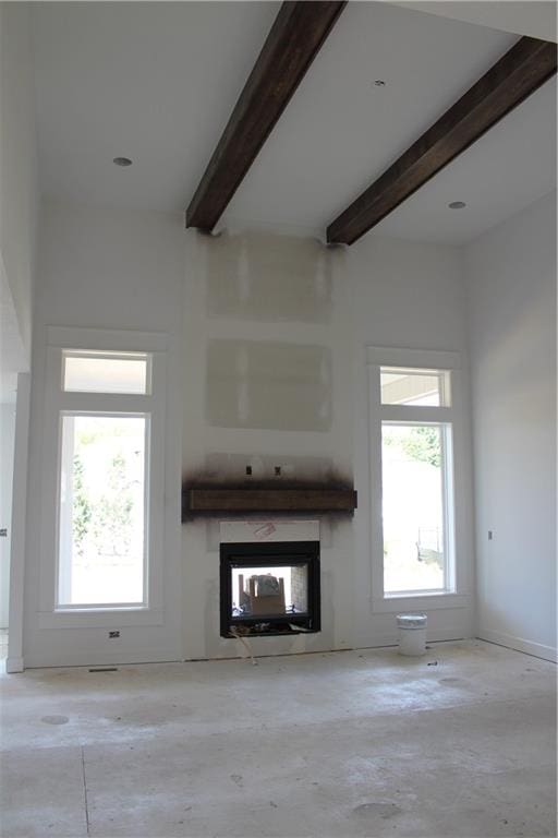 unfurnished living room with beam ceiling