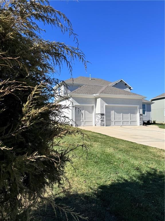 view of front of home with a front yard and a garage