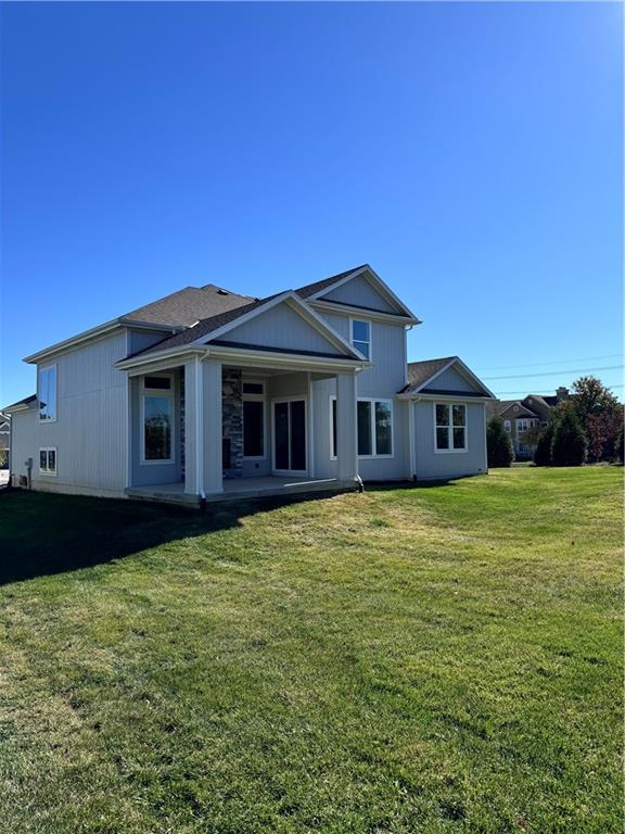 rear view of house with a patio area and a lawn