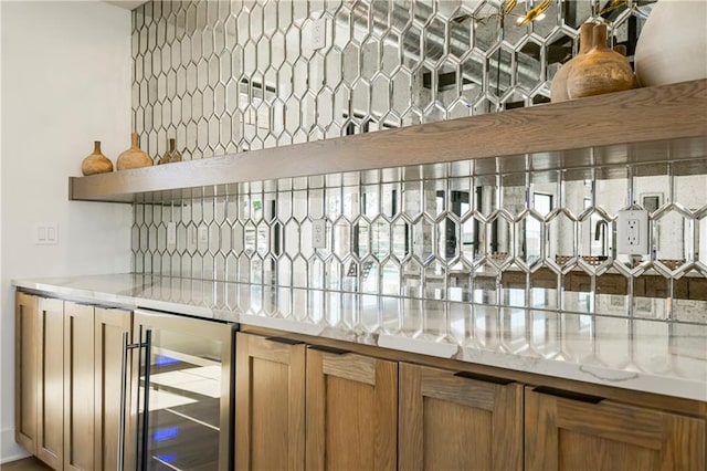 bar with light stone countertops and beverage cooler