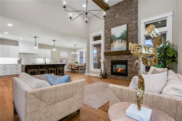 16388 S Brougham Dr, Olathe, KS 66062 - living area with an inviting chandelier, recessed lighting, light wood-style flooring, and a stone fireplace