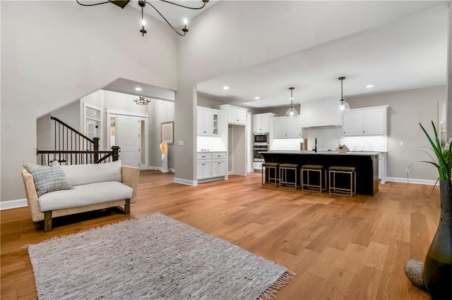 16388 S Brougham Dr, Olathe, KS 66062 - living room featuring baseboards, a notable chandelier, and light wood-style flooring