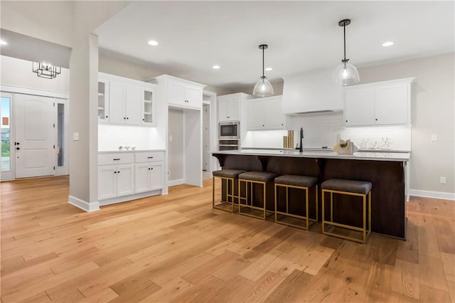 16388 S Brougham Dr, Olathe, KS 66062 - kitchen featuring backsplash, appliances with stainless steel finishes, light wood-type flooring, light countertops, and white cabinets