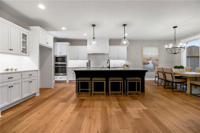 16388 S Brougham Dr, Olathe, KS 66062 - kitchen featuring appliances with stainless steel finishes, a sink, a chandelier, light wood-style flooring, and recessed lighting