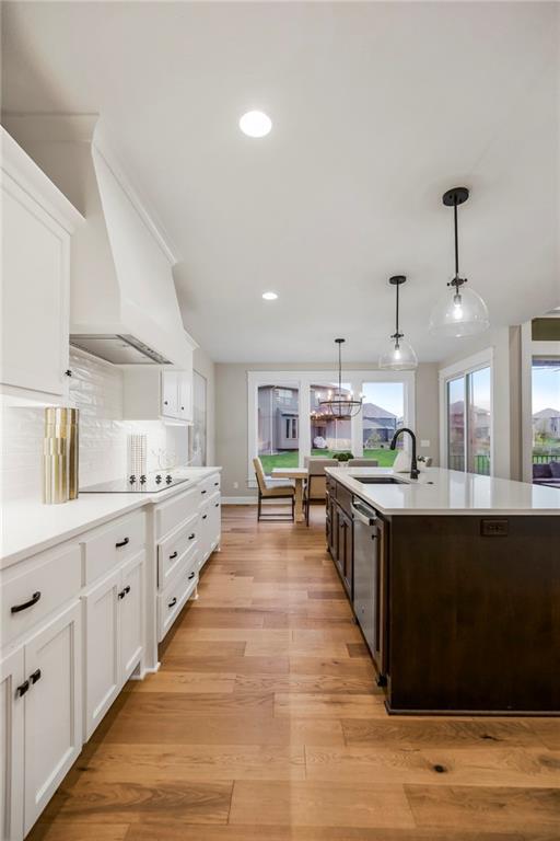 16388 S Brougham Dr, Olathe, KS 66062 - kitchen featuring a sink, black electric cooktop, custom exhaust hood, and light countertops