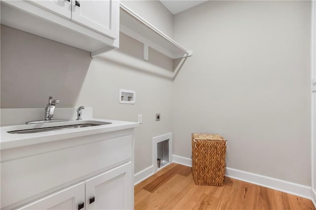 16388 S Brougham Dr, Olathe, KS 66062 - washroom featuring hookup for a washing machine, light wood-type flooring, electric dryer hookup, a sink, and cabinet space