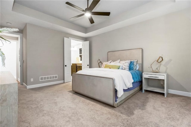 16388 S Brougham Dr, Olathe, KS 66062 - carpeted bedroom with visible vents, baseboards, connected bathroom, a tray ceiling, and a ceiling fan
