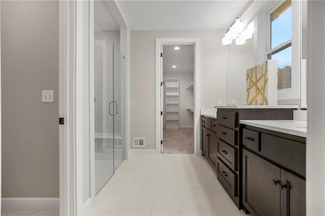 16388 S Brougham Dr, Olathe, KS 66062 - bathroom featuring vanity, marble finish floor, a shower stall, a spacious closet, and visible vents